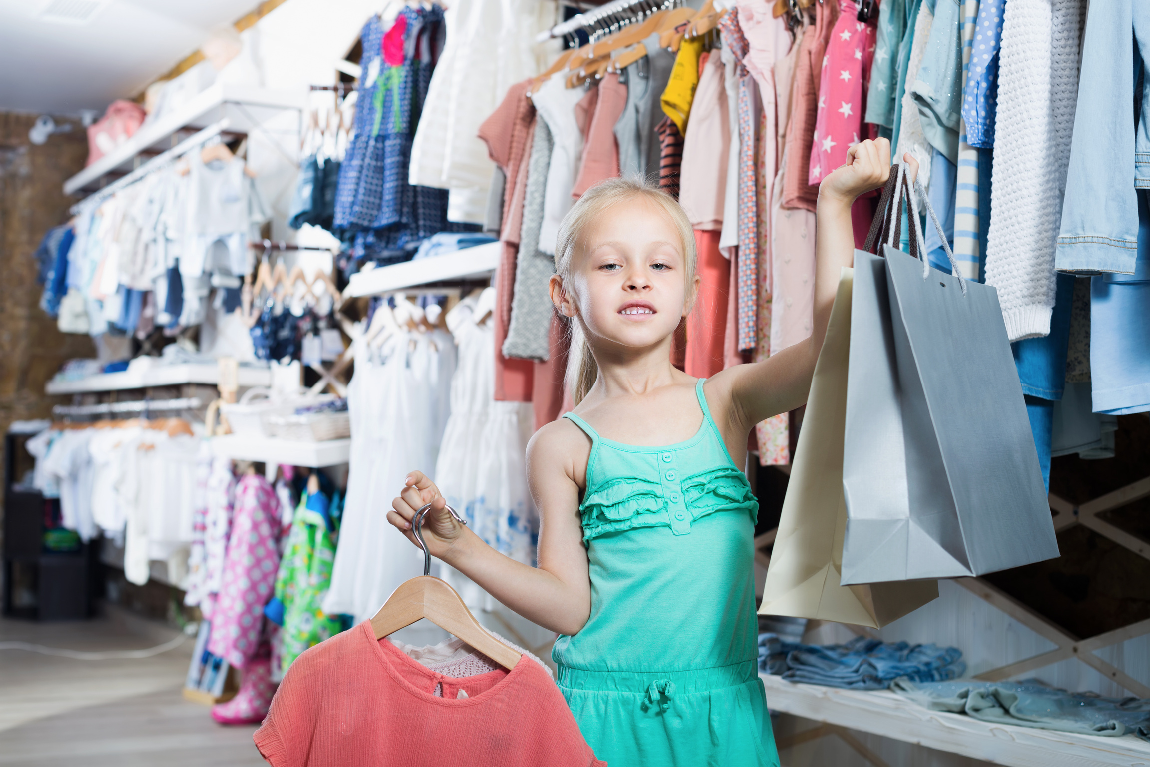 Small girl holding  bags in children boutique